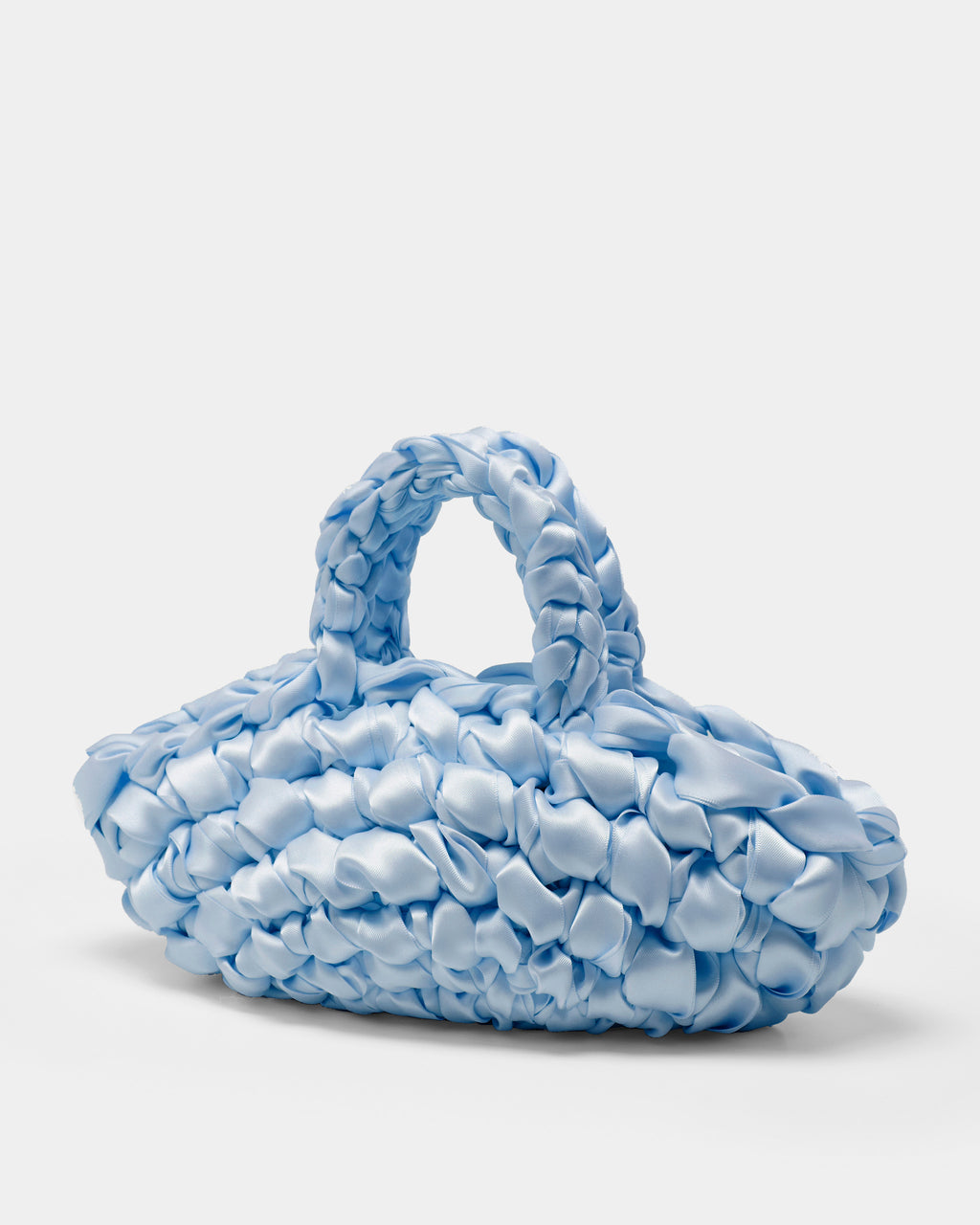 The Quintessential Bridal Bag. Introducing the Nest. Every ISLA DE GAR bag begins with a ribbon, a crochet hook, and a pattern - but that's where the similarities end. This unique design weaves together two lengths of satin, creating a beautifully tactile, sculptural croissant bag that's irresistibly plush and impossible to ignore.