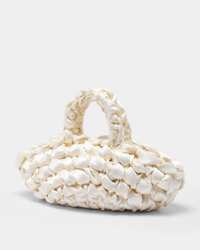 The Quintessential Bridal Bag. Introducing the Nest. Every ISLA DE GAR bag begins with a ribbon, a crochet hook, and a pattern - but that's where the similarities end. This unique design weaves together two lengths of satin, creating a beautifully tactile, sculptural croissant bag that's irresistibly plush and impossible to ignore.